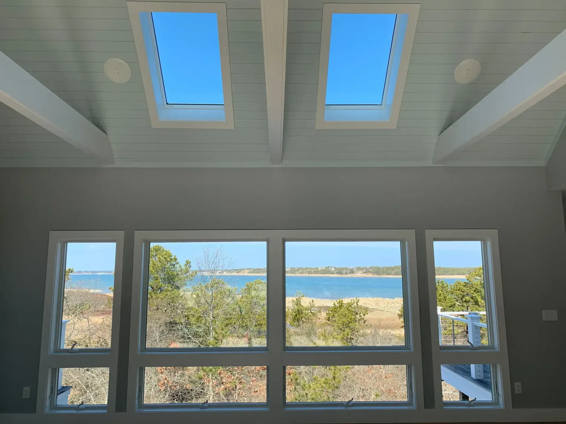 Waterfront home interior with large windows overlooking a Cape Cod bay built by Tuleika Building Company