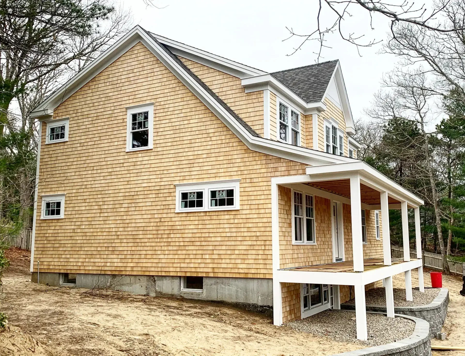 Cedar shingle home addition with new covered porch under construction on Cape Cod by Tuleika Building Company